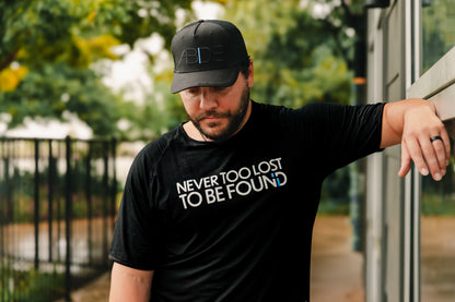 christian man with beard wearing now found christian apparel blackout "abide" trucker hat and "never too lost" black bamboo shirt