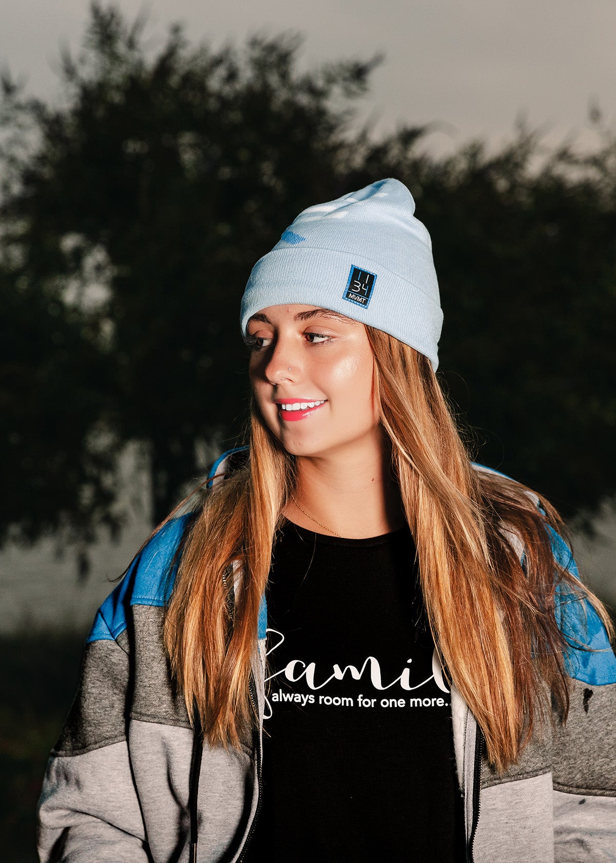 beautiful christian female youth wearing blue "i am" beanie and zip-up hoodie with a "family" bamboo tee from now found apparel.