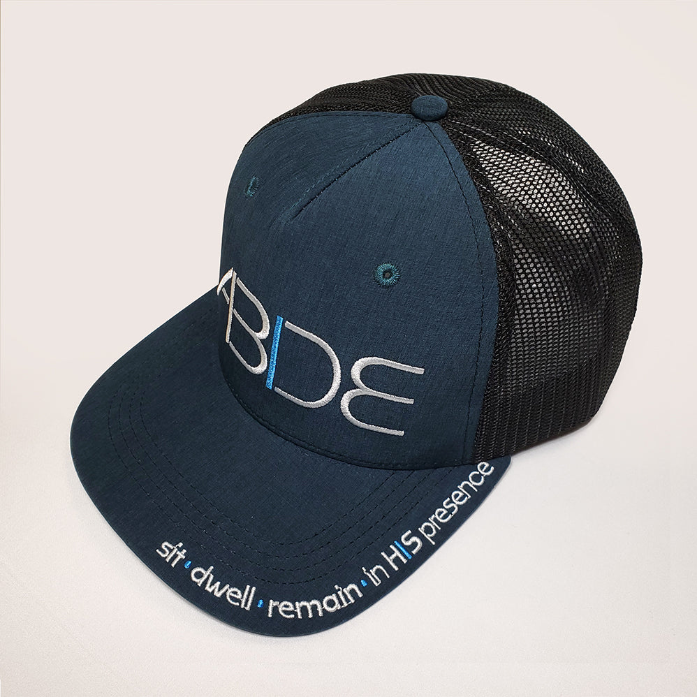 Ocean blue "Abide" trucker hat with a sit - dwell - remain in His presence on the bill and striking "Abide" design on front