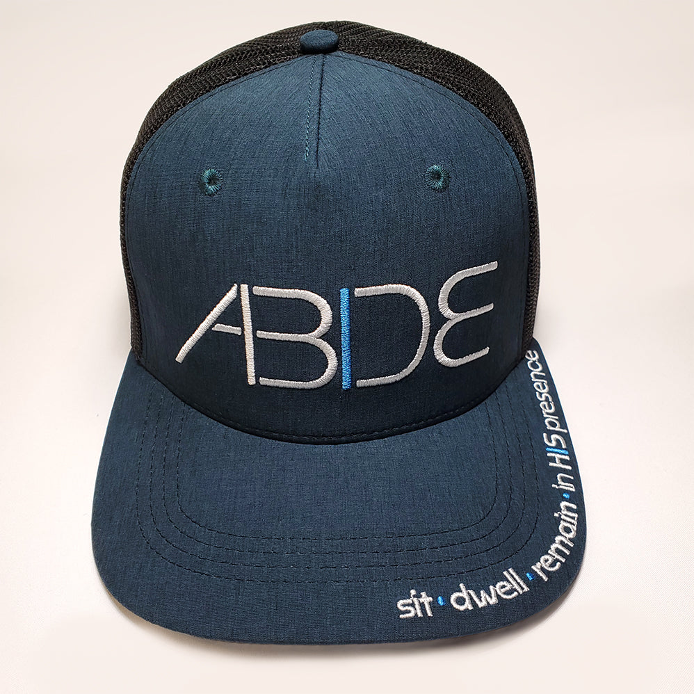 Ocean blue "Abide" trucker hat with a sit - dwell - remain in His presence ebroidered on the bill and Agressive "Abide" design on front